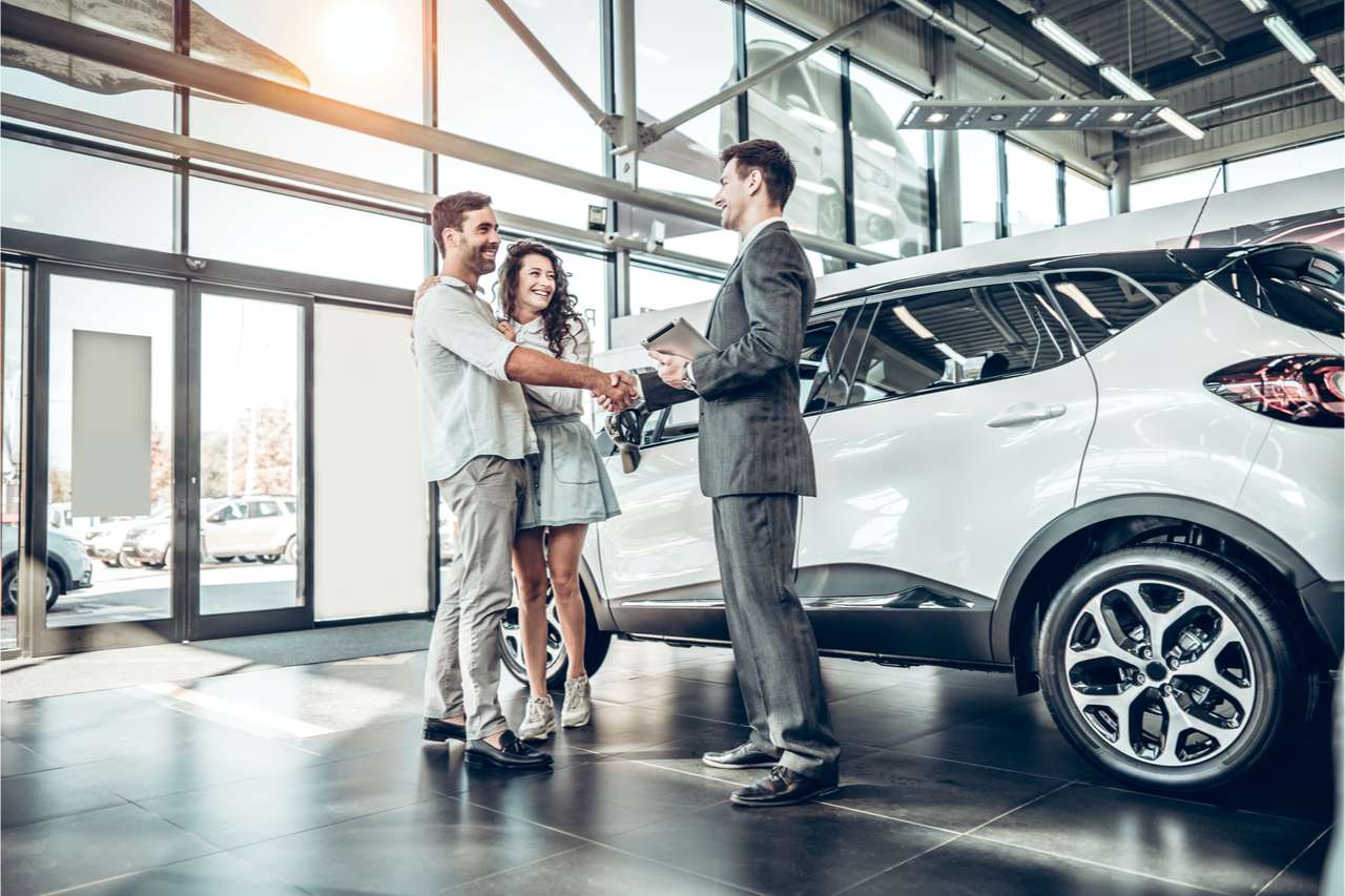 A couple purchasing a new car at a dealership